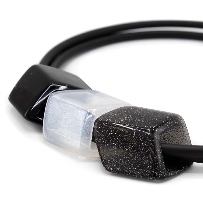 Detail van ketting met rubber met drie cubes in zwart en wit 