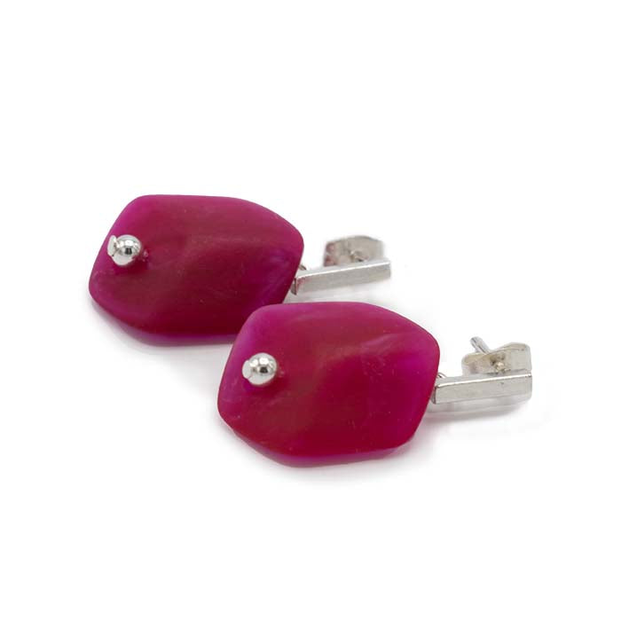 Cube oorbellen Cerise van resin, liggend weergegeven met zilverkleurige stud.