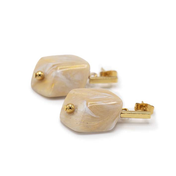 Cube oorbellen Ivory van resin, liggend weergegeven met goudkleurige stud.