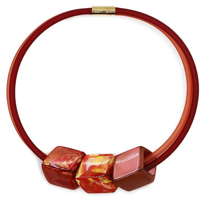 Ketting met 3 Cubes in warme tinten oranje, rood en koper aan rode rubber ketting met goudkleurige sluiting, front.