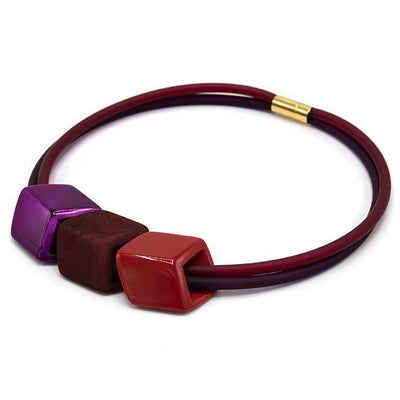 Ketting met 3 Cubes in rood, bordeaux en fuchsia aan donkerrode rubber ketting met goudkleurige sluiting, zijaanzicht.