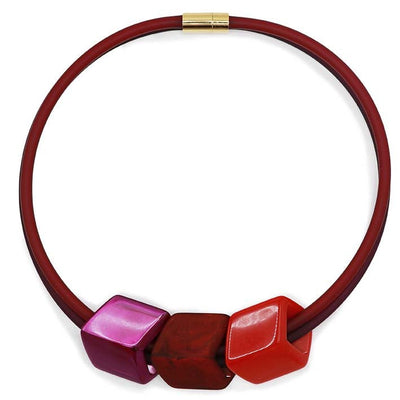Ketting met 3 Cubes in rood, bordeaux en fuchsia aan donkerrode rubber ketting met goudkleurige sluiting, front.