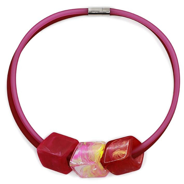 Ketting met 3 Cubes in felle tinten roze, geel en rood aan roze rubber ketting met zilverkleurige sluiting, front.