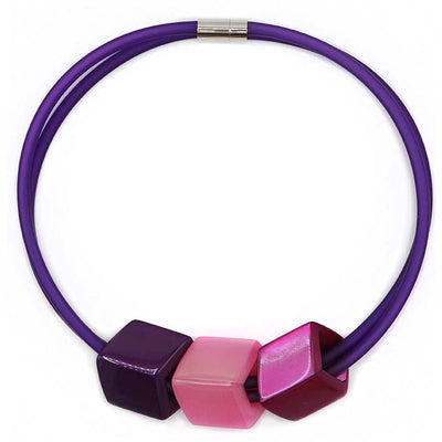 Ketting met 3 Cubes in paarstinten (paars, roze, magenta) aan paarse rubber ketting met zilverkleurige sluiting, frontaal.